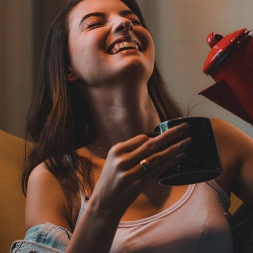 飲み物を注ぎながら笑っている女性イメージ